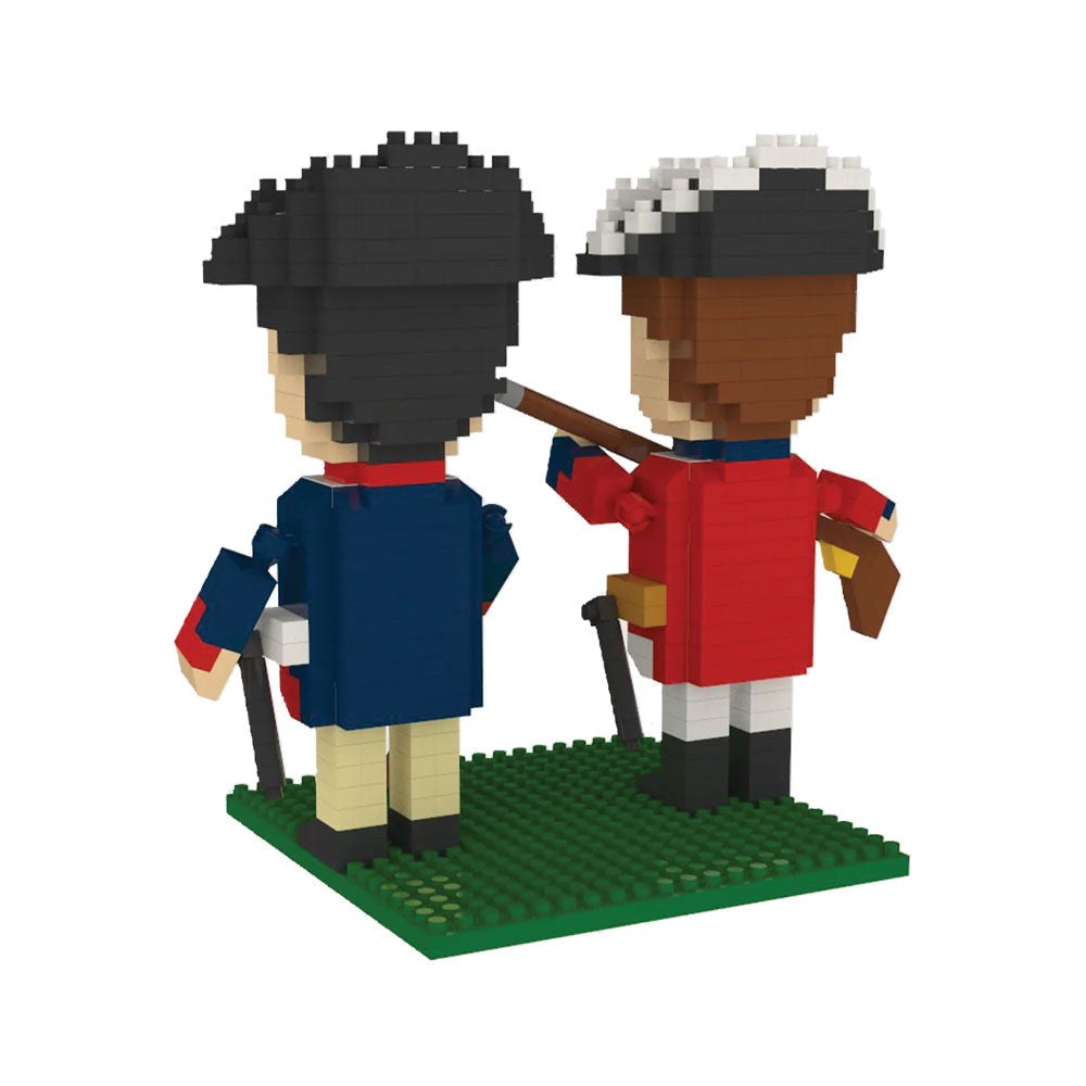 The Revolutionary War Soldiers Mini Blocks set includes two blocky figures on a green base, dressed in colonial uniforms—one in blue and beige, the other in red and white with a musket. Both wear black hats with white trim.