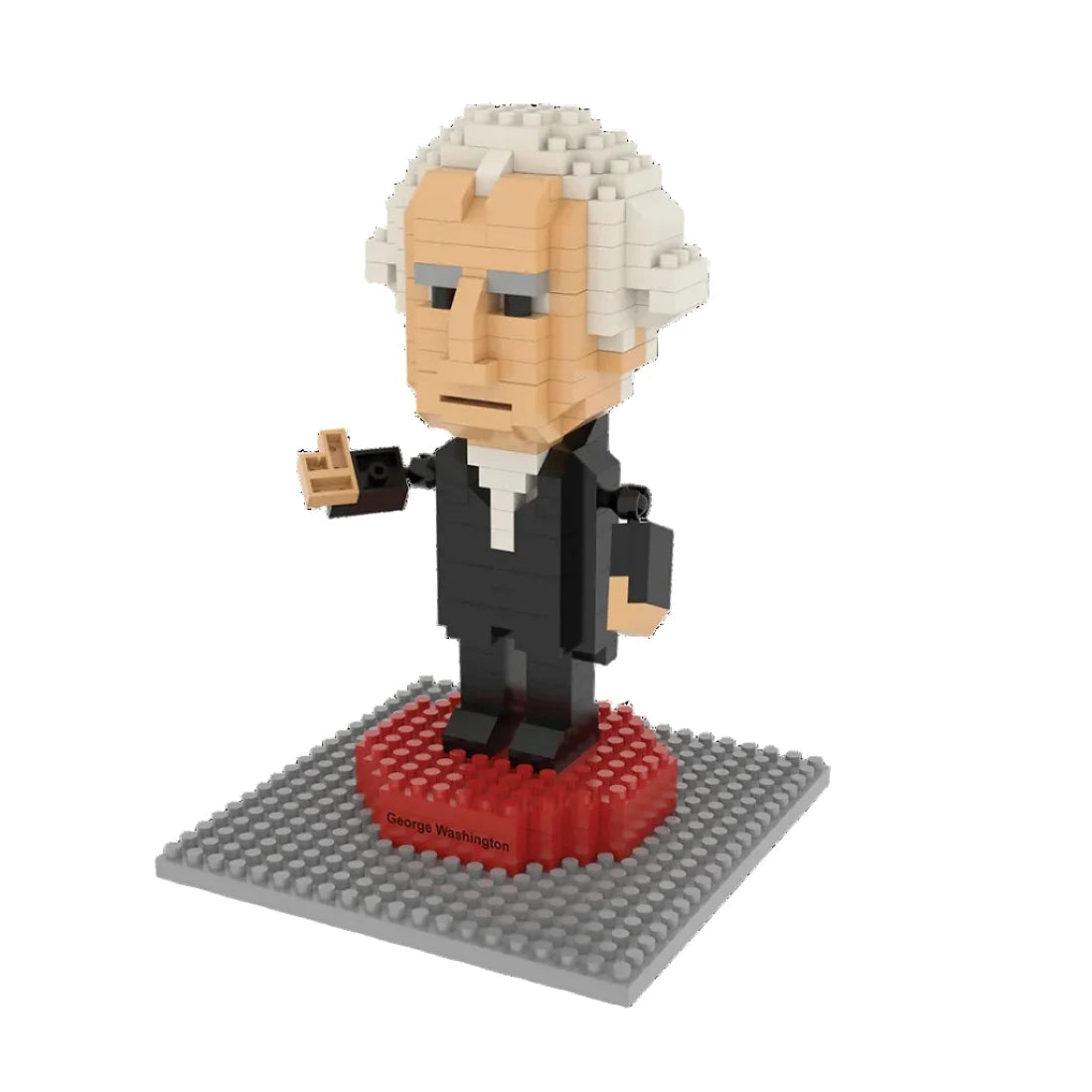 The George Washington Mini Blocks set features a 323-piece figurine of George Washington in a black suit with white hair, standing on a red and gray base labeled "George Washington," holding a book and gesturing with one hand.