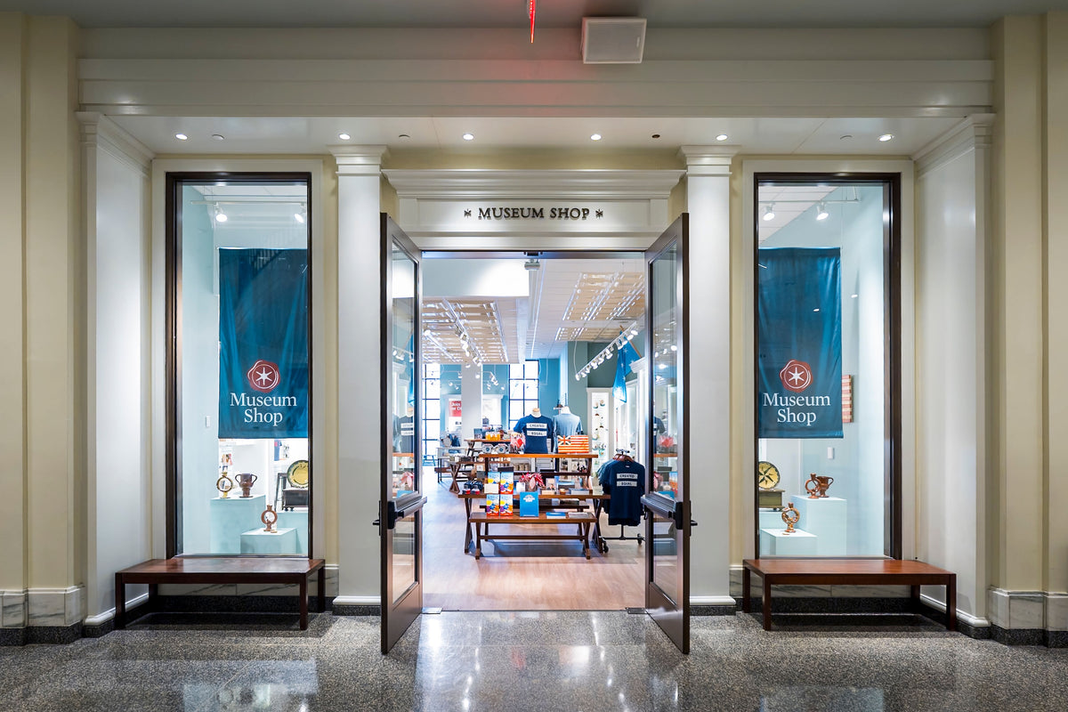 Museum shop entrance with 'Museum Shop' sign and display cases.