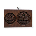 The Liberty Bell & Independence Hall Cookie Mold is a wooden plaque featuring two carved emblems—a beehive with leaves and Greek letters, and Independence Hall with three towers—with a metal hanging loop at the top.