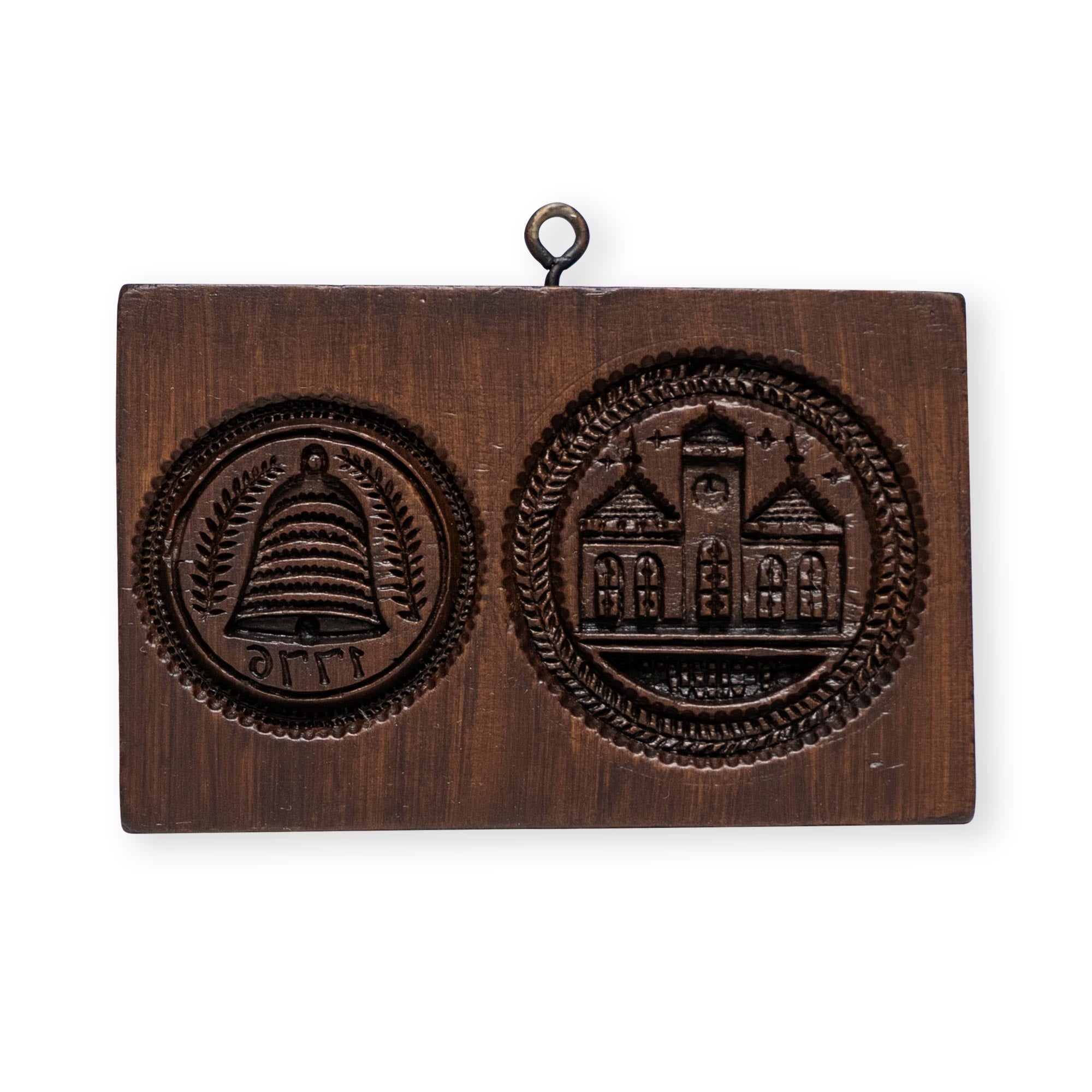 The Liberty Bell & Independence Hall Cookie Mold is a wooden plaque featuring two carved emblems—a beehive with leaves and Greek letters, and Independence Hall with three towers—with a metal hanging loop at the top.