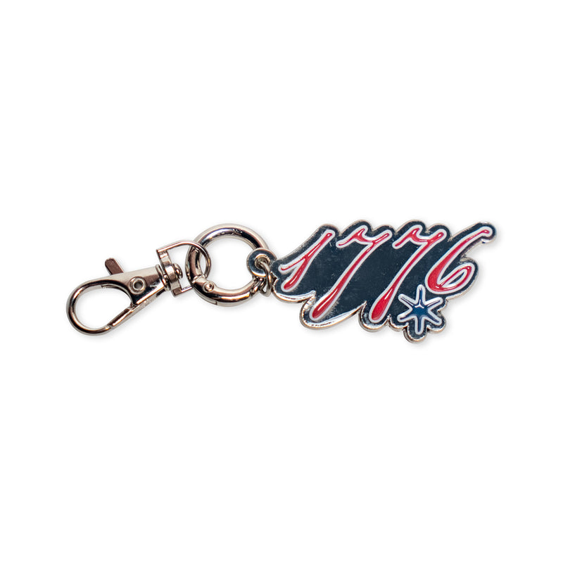 Introducing the 1776 Keychain—a commemorative accessory featuring a durable metal clasp and a decorative charm boldly displaying "1776" in vivid red and blue, accented with a starburst detail beside the numbers. It's the perfect keepsake for celebrating America's founding.