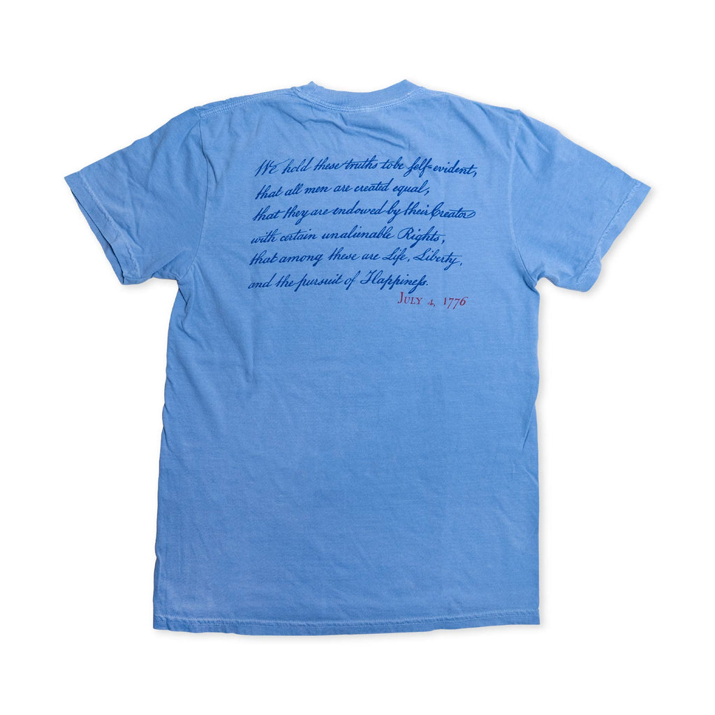 Introducing the “We Hold These Truths 1776 T-Shirt” in washed denim, featuring script from the Declaration of Independence on the back in blue font, with “July 4, 1776” highlighted in red. Laid flat to showcase its prominent text, this shirt is perfect for anyone who appreciates American history.