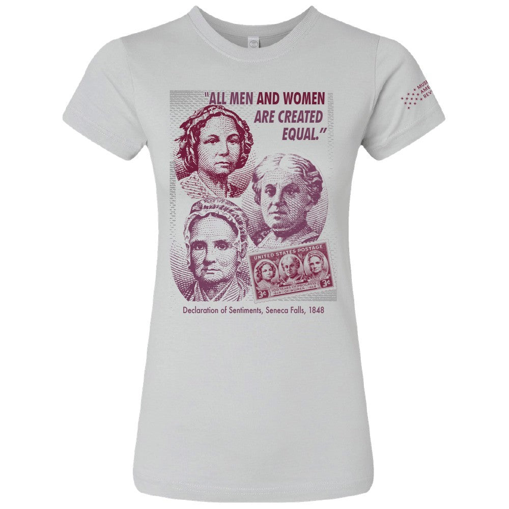 Celebrate history with the Seneca Falls T-Shirt, featuring portraits of three women, a postage stamp, and the quote “All men and women are created equal,” honoring the 1848 Seneca Falls Convention and Declaration of Sentiments.