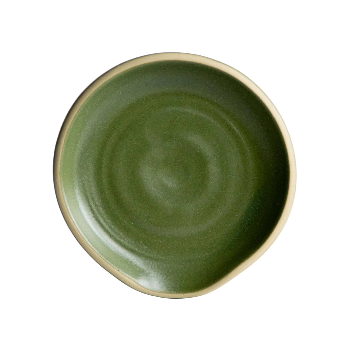 A small, round Handcrafted Stoneware Spoon Rest with a glossy green center and beige rim, featuring a slightly uneven edge—this ceramic piece is handmade in the USA and ideal for keeping your kitchen organized.
