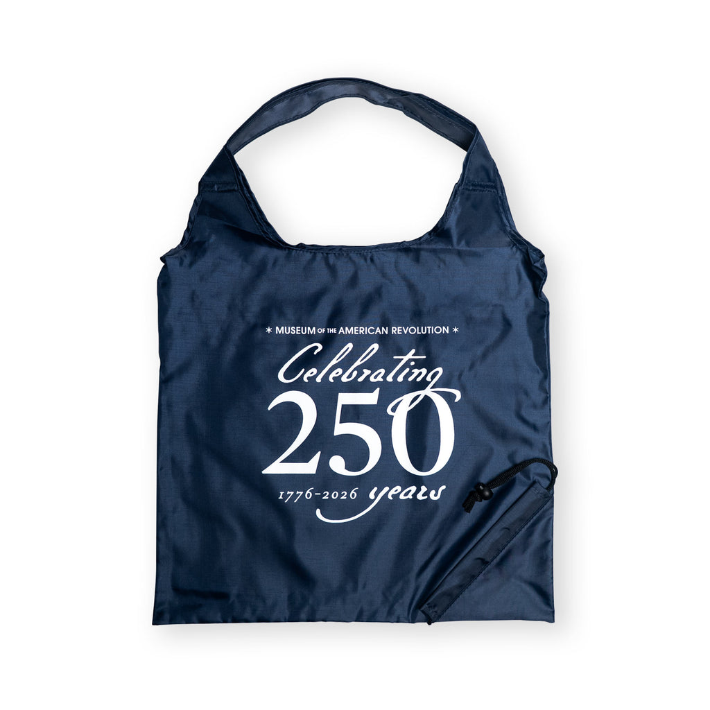 The Celebrating 250 Packable Tote Bag in navy features white "Museum of the American Revolution Celebrating 250 years 1776–2026" text, a built-in handle, and attached drawstring pouch—perfect for everyday use.
