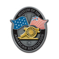The Flags Magnet features an oval emblem reading Museum of the American Revolution, a gold cannon with two crossed Revolutionary War flags, and a small star on a gray background.