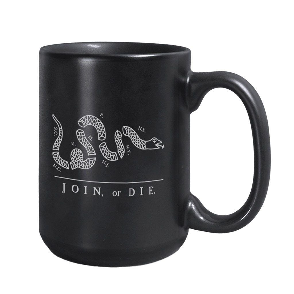 The Join or Die Mug is a black ceramic mug with a white segmented snake illustration and iconic text, inspired by Benjamin Franklin’s American Revolution design.