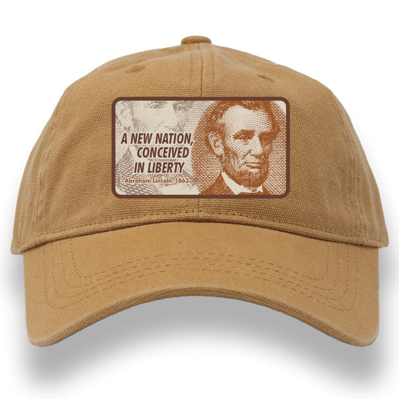 The Abraham Lincoln Cap features a tan design with Lincoln's image and the quote: "A NEW NATION, CONCEIVED IN LIBERTY — Abraham Lincoln, 1863." 