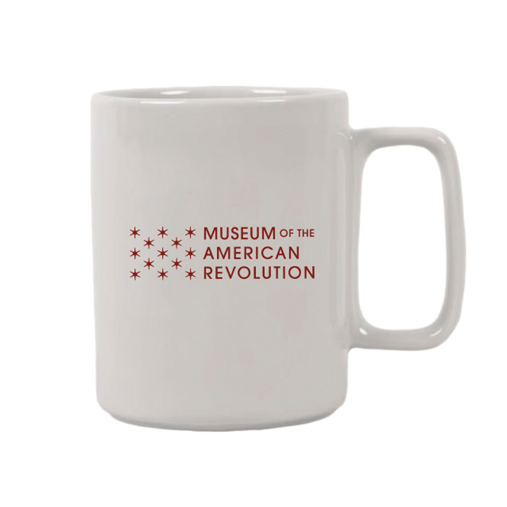 The Seneca Falls Mug is a white ceramic mug featuring the Museum of the American Revolution logo in red and a cluster of stars beside the museum name, commemorating the Women’s Rights Convention.
