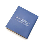 The Declaration Quote Journal is a blue compact notebook with "Museum of the American Revolution" and a white star design on the cover. Shown slightly open against a white background.