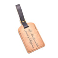 The "Life, Liberty, and the Pursuit of Happiness" Luggage Tag is crafted from durable brown leather with a black strap and gold buckle, featuring elegant cursive engraved text.