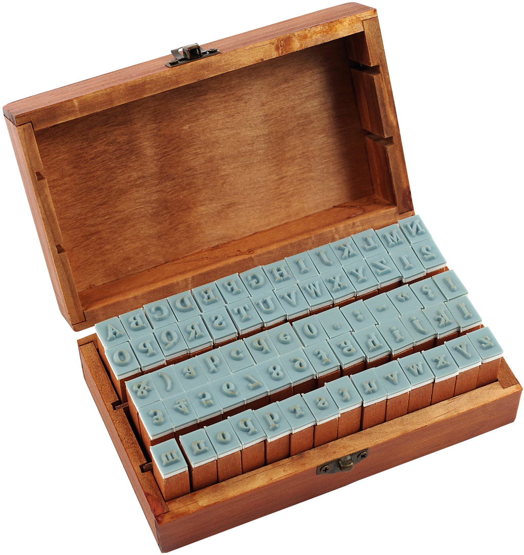 The Letterpress Stamp Set comes in a wooden box with the lid open, displaying two rows of blue rubber-tipped wooden stamps featuring letters, numbers, and symbols arranged neatly inside.