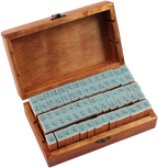 The Letterpress Stamp Set comes in a wooden box with the lid open, displaying two rows of blue rubber-tipped wooden stamps featuring letters, numbers, and symbols arranged neatly inside.