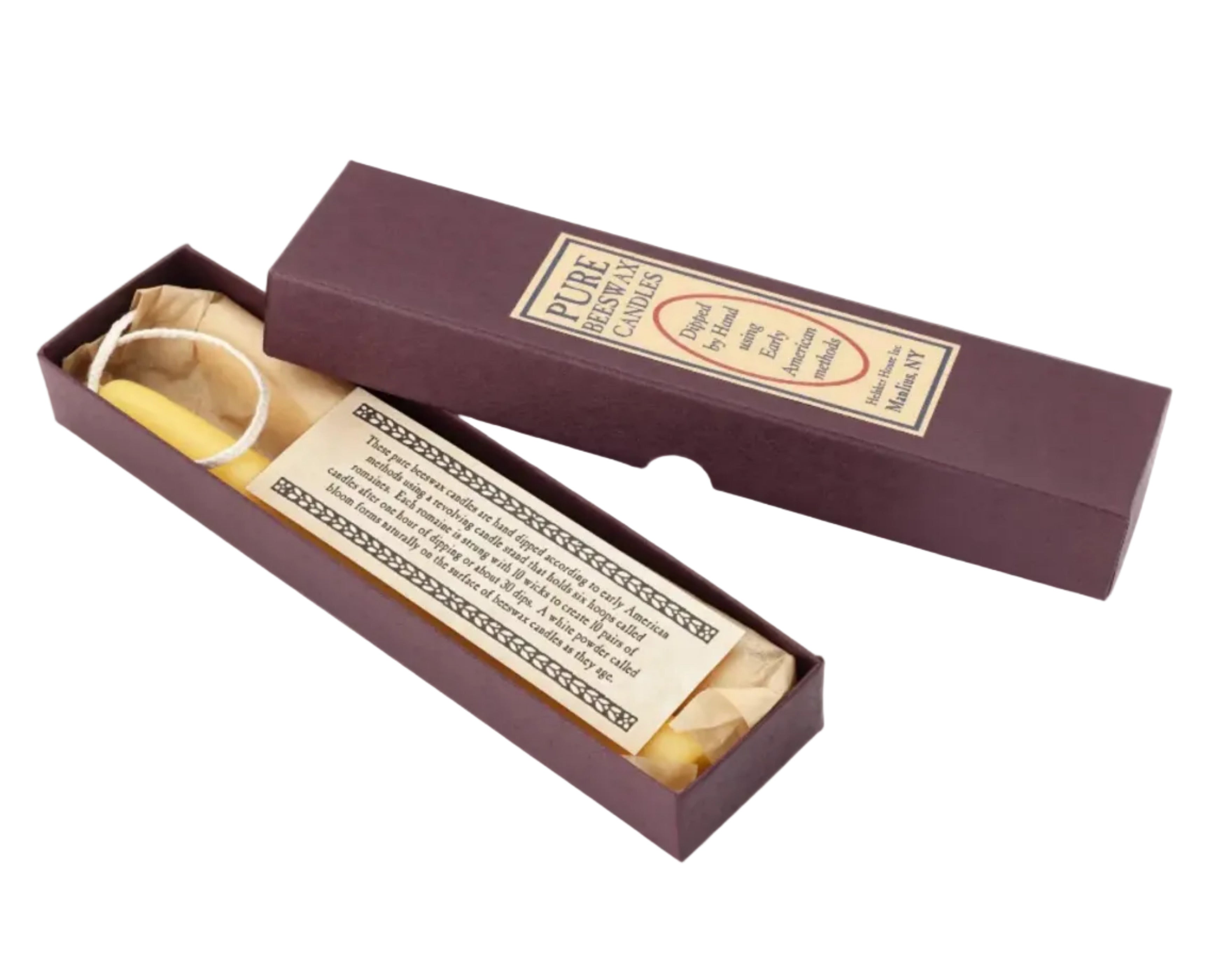 A maroon rectangular box labeled "Beeswax Taper Candle" holds a yellow hand-dipped beeswax taper candle and an informational card, with the partially open lid revealing the contents, all displayed on a white background.