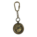 The Antiqued Brass Compass Keychain features a round vintage-style brass compass with engraved direction markings, attached to a loop and chain. The metallic finish is showcased against a white background.