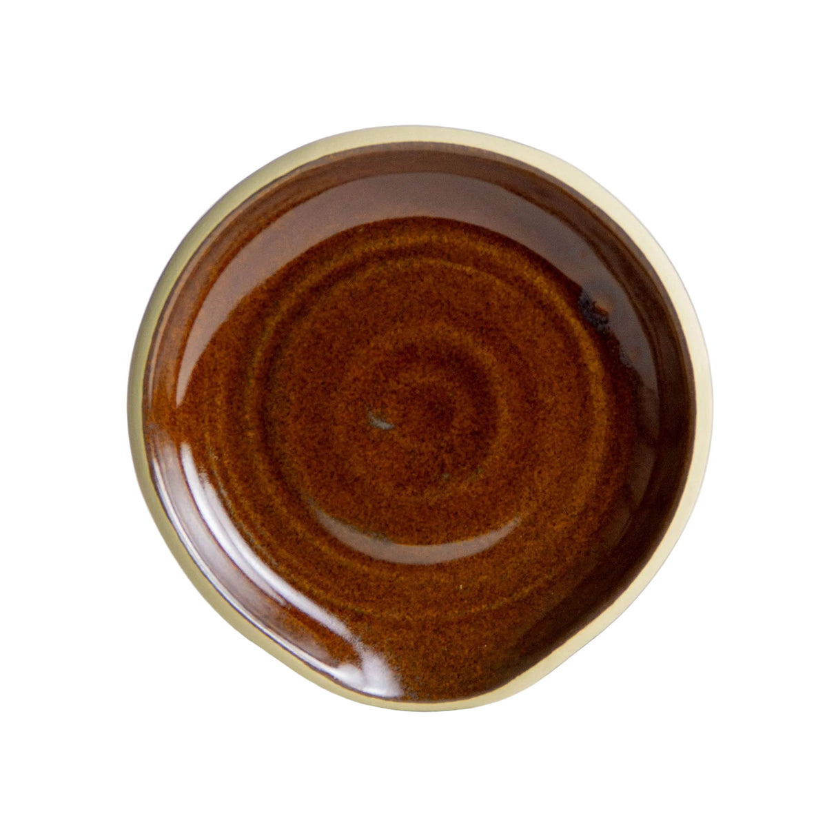 The Handcrafted Stoneware Spoon Rest is a small, round ceramic plate with a glossy brown center and a beige rim, viewed from above. Handmade in the USA, it showcases a simple, rustic design with an uneven rim—perfect for stylish kitchen organization.