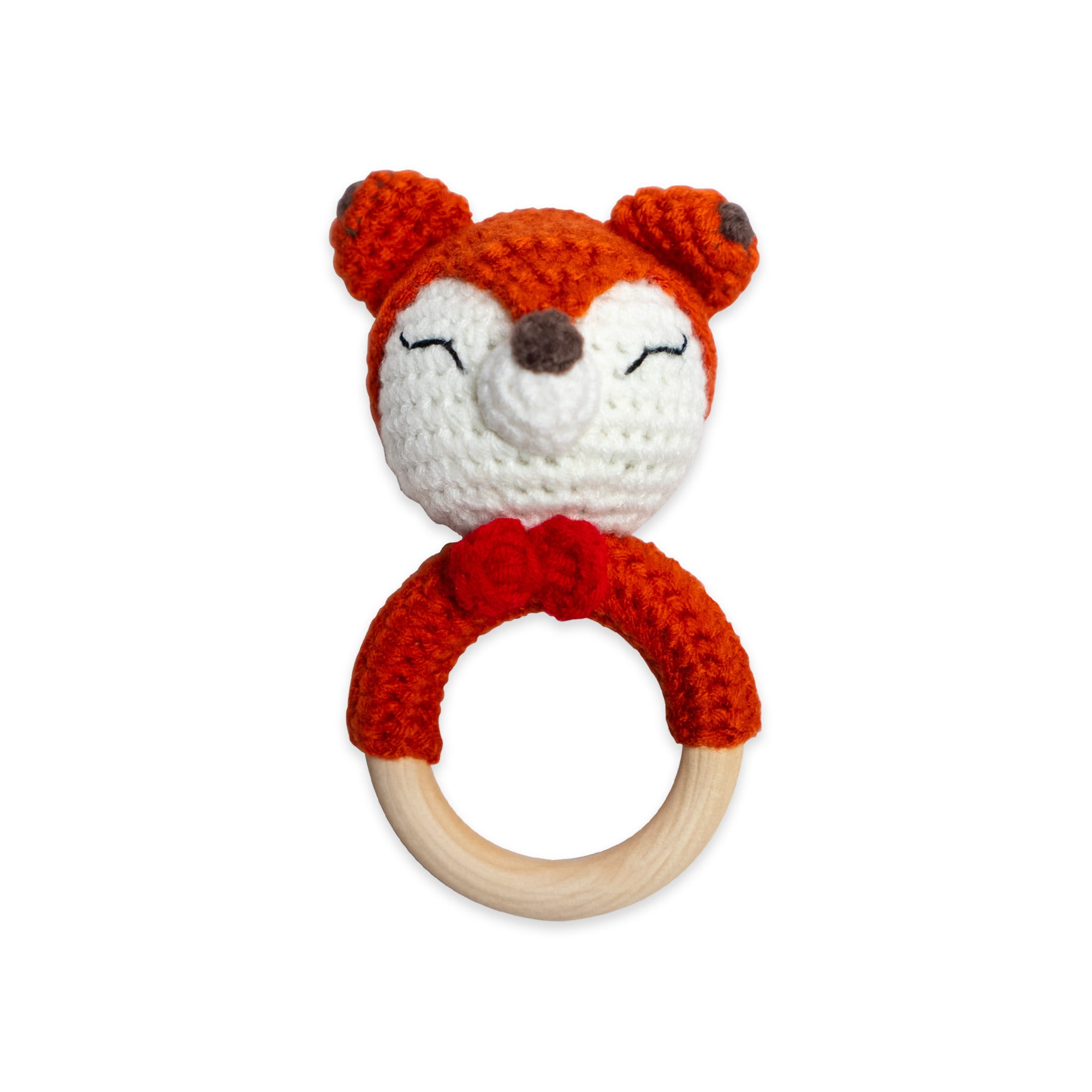 The Hand Crochet Rattle features a crocheted fox head with a red bow, attached to a wooden teething ring, and is made from organic cotton baby-safe materials, displayed on a white background.