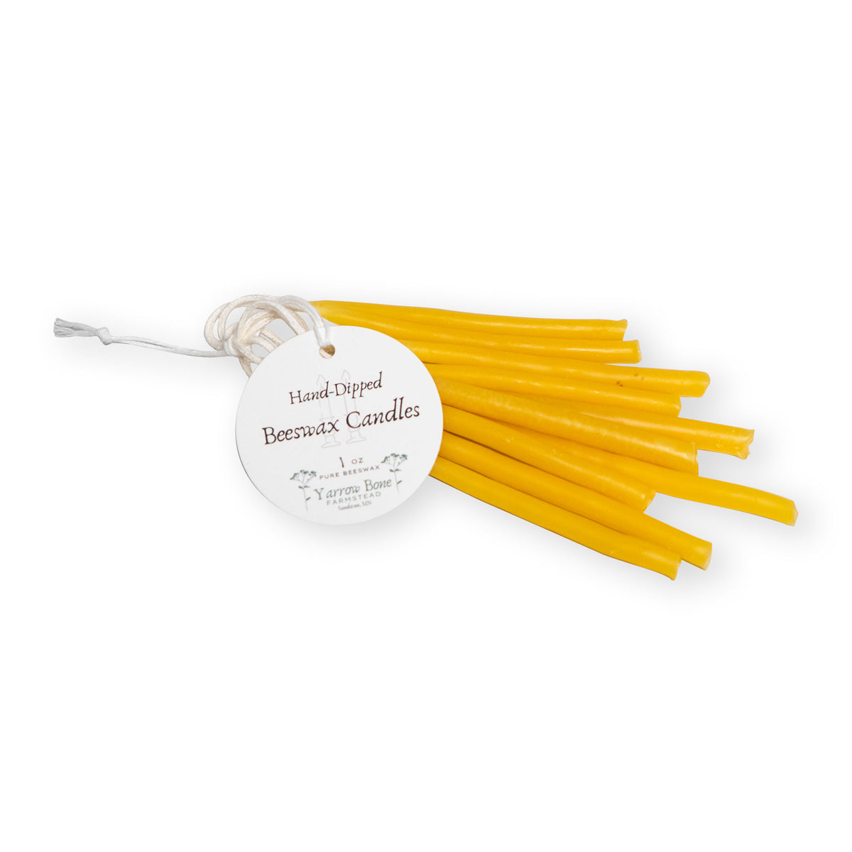 A bundle of thin, yellow Small Hand Dipped Beeswax Taper Candles tied with a round tag.