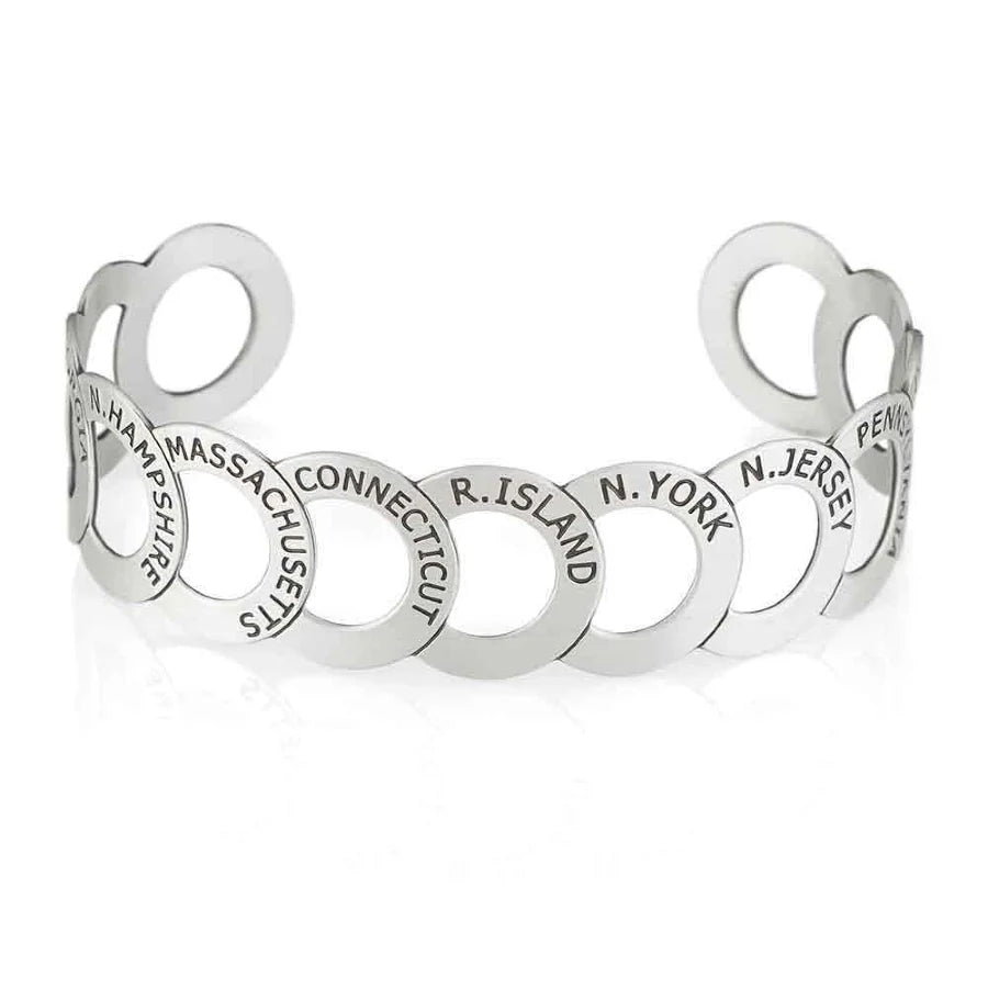 The Chain of States Bracelet is a silver piece with interlocking rings, each engraved with the name of an original state, inspired by thirteen colonies jewelry.