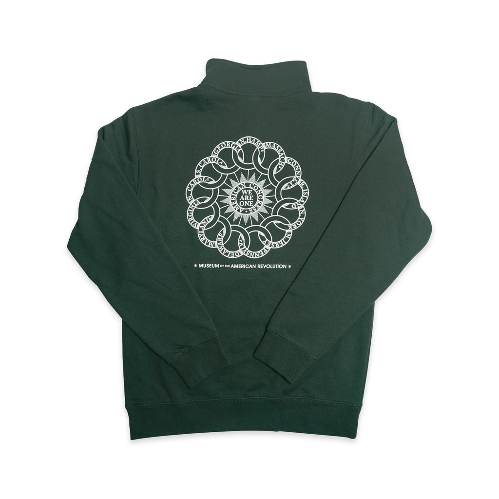 A dark green Chain of States Quarter Zip Sweatshirt featuring a circular white graphic and text on the back, reading “We the People,” surrounded by decorative elements. Below the circle: Museum of the American Revolution. Perfect for those seeking American unity clothing inspired by colonial history apparel.