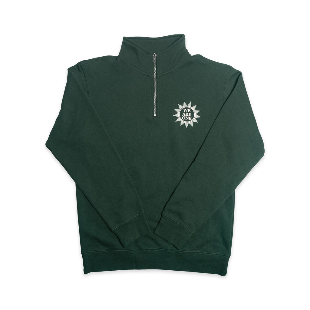 The Chain of States Quarter Zip Sweatshirt is a dark green quarter-zip with a zipper at the collar. A white sunburst design with the words WE ARE ONE appears on the left chest, reflecting themes of American unity and colonial history. Laid flat on a white background, this standout piece is ideal for anyone interested in historic-inspired apparel.
