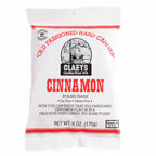 A white bag of Cinnamon Old Fashioned Hard Candies features red text, a candy maker illustration, and highlights that the candies are artificially and naturally flavored as well as fat free.