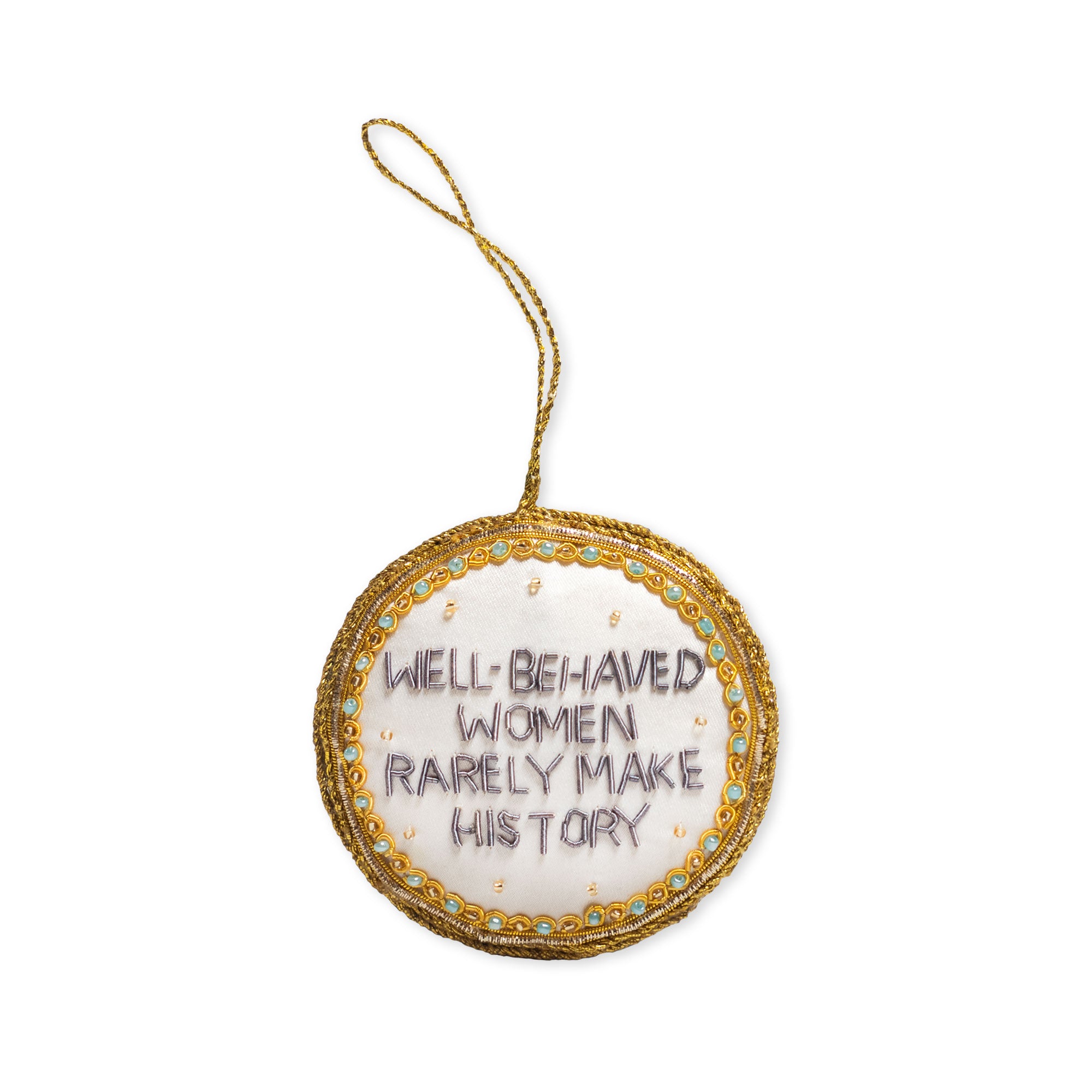 The Well-Behaved Women Ornament is a round, feminist ornament featuring a gold trim and hanging loop. Embroidered in purple thread on white fabric are the words "WELL-BEHAVED WOMEN RARELY MAKE HISTORY." This unique history ornament brings an empowering accent to your décor.
