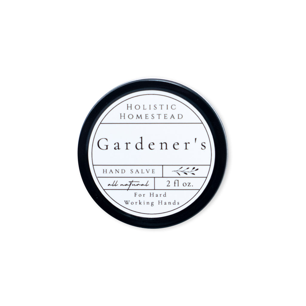 A round tin of Holistic Homestead Gardener’s Hand Salve with a white label featuring the text all natural, 2 fl oz, For Hard Working Hands.