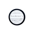 A round tin of Holistic Homestead Gardener’s Hand Salve with a white label featuring the text all natural, 2 fl oz, For Hard Working Hands.