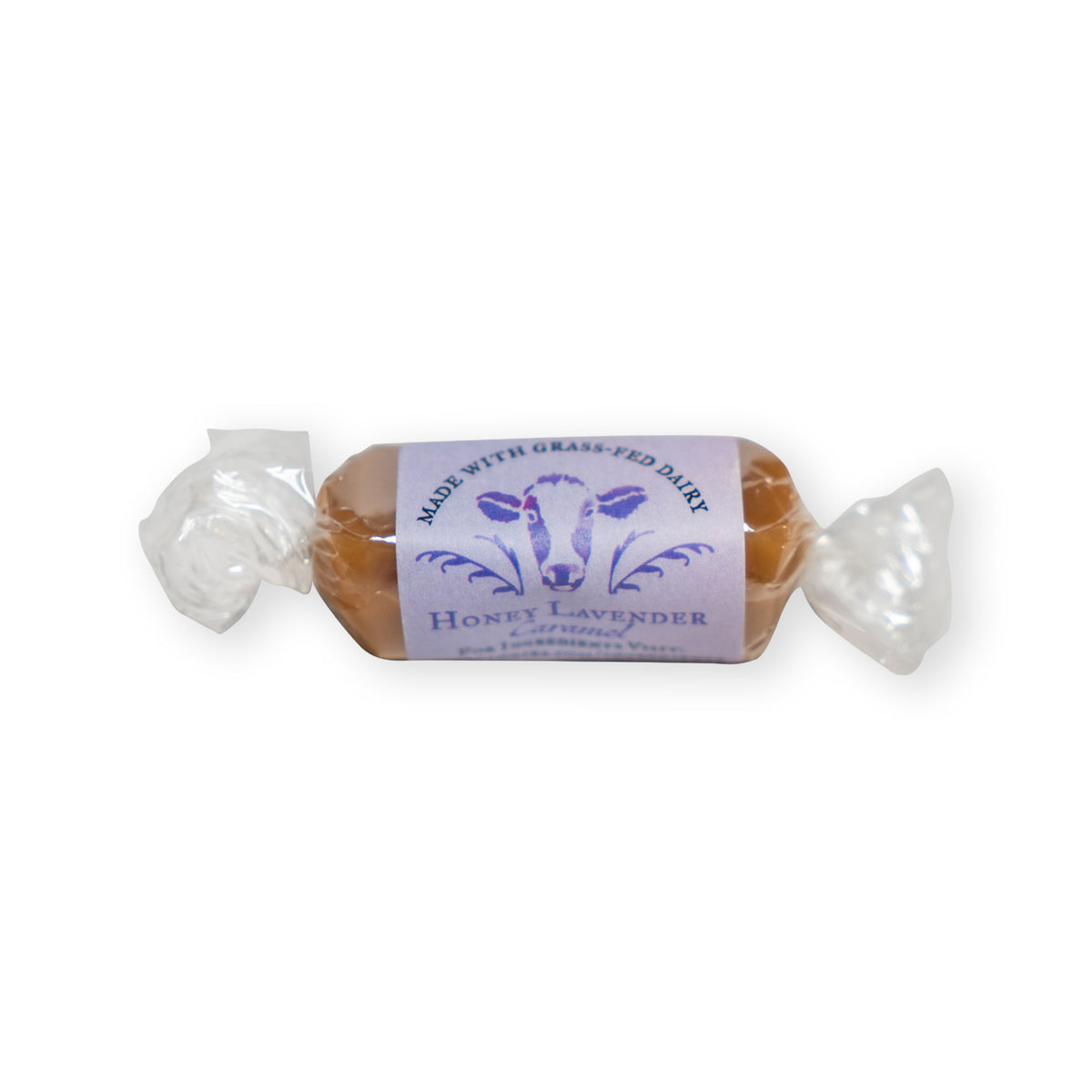 A single Honey Lavender Soft Caramels wrapped in clear plastic with a label featuring a cow illustration and the text Made with grass-fed dairy.