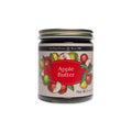 A glass jar of no sugar added Apple Butter with a label featuring illustrations of apples and the text Tait Farm Foods and Net Wt 9 oz.