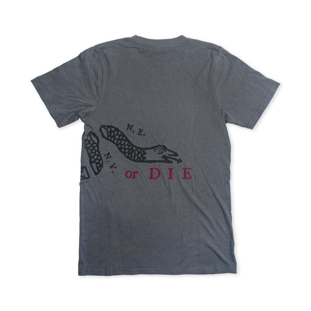 The Join or Die Crewneck T-Shirt features a gray base adorned with a bold black snake graphic and the text “N.E. NY. or DIE” across the back, channeling the rebellious energy of Revolutionary-era political art. The snake wraps partially around the shirt, while “or DIE” stands out in vivid red—a modern tribute to the iconic American Revolution-era Join or Die T-shirt design.