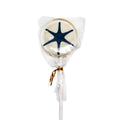 A Museum Logo Lollipop, featuring a round strawberry shape with a blue starfish design, is wrapped in clear plastic and tied with a gold twist tie. It sits on a white stick against a plain white background—a sweet treat that echoes flavors enjoyed throughout American history.