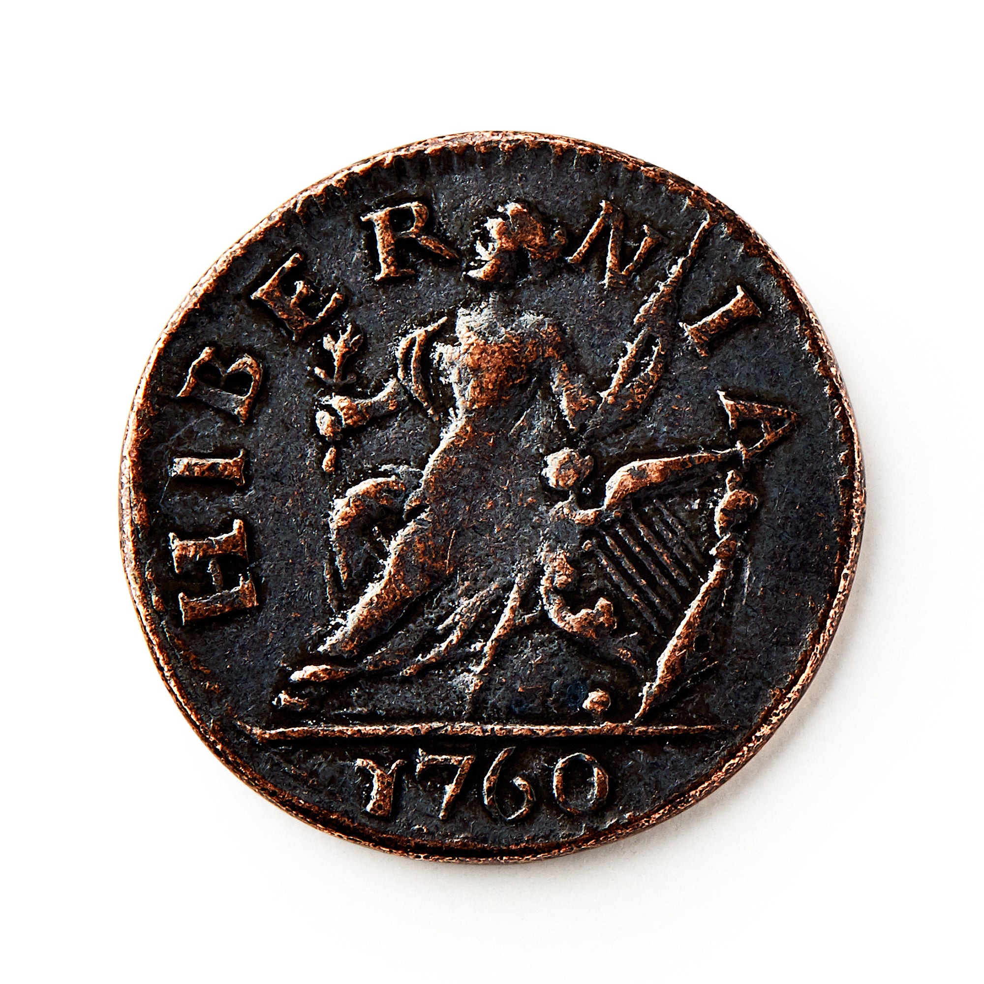 A worn 1760 Voce Populi Farthing, a copper coin from colonial America, displays a seated female figure with a harp, “HIBERNIA” above, and “1760” below—an artifact of pre-Revolutionary commerce.