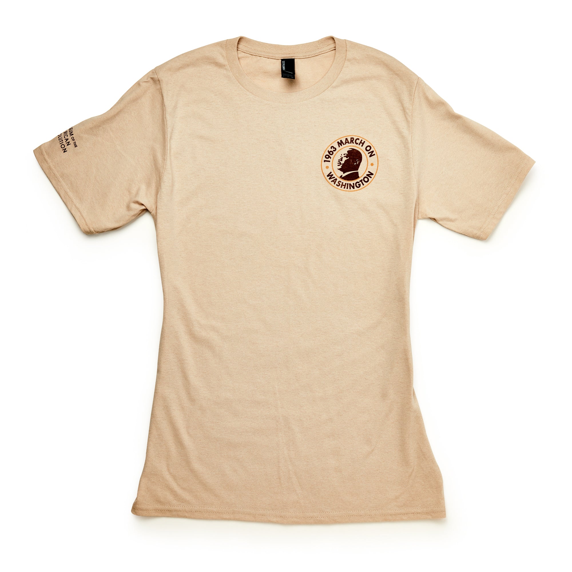 The March on Washington T-Shirt, Natural, features a small round "1963 March on Washington" civil rights logo and an image of Martin Luther King Jr. on the left chest, plus text near the right shoulder. Short sleeves and neutral beige color.