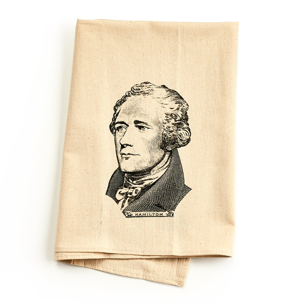 A folded, light tan Alexander Hamilton Engraving Tea Towel featuring a black ink engraving of the historical figure.
