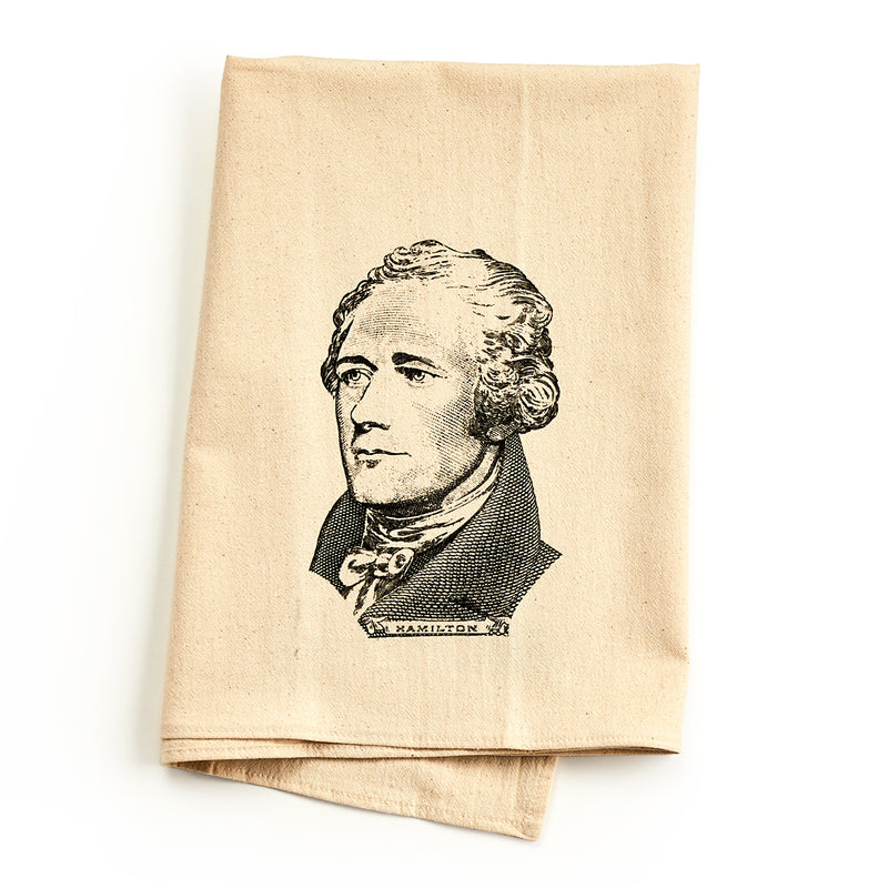 A folded, light tan Alexander Hamilton Engraving Tea Towel featuring a black ink engraving of the historical figure.