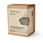 A brown cardboard box labeled America Candle holds a soy blend candle. The label shows a steaming apple pie and notes it's a hand-poured apple pie candle, perfect for making your home cozy.