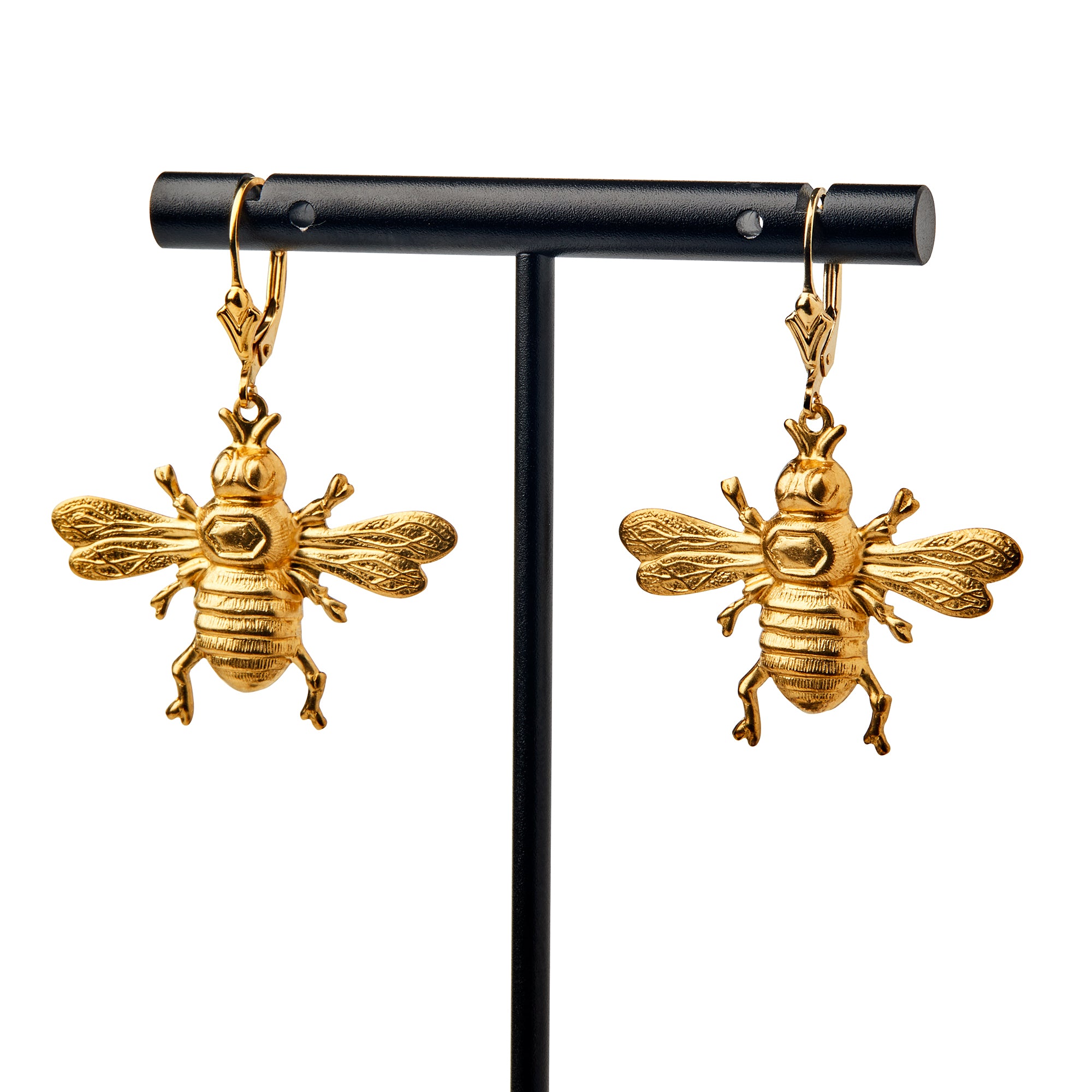 Bee Earrings featuring detailed gold bee designs with intricate wings and bodies, shown hanging from a black stand on a white background—ideal for fans of nature-inspired jewelry.