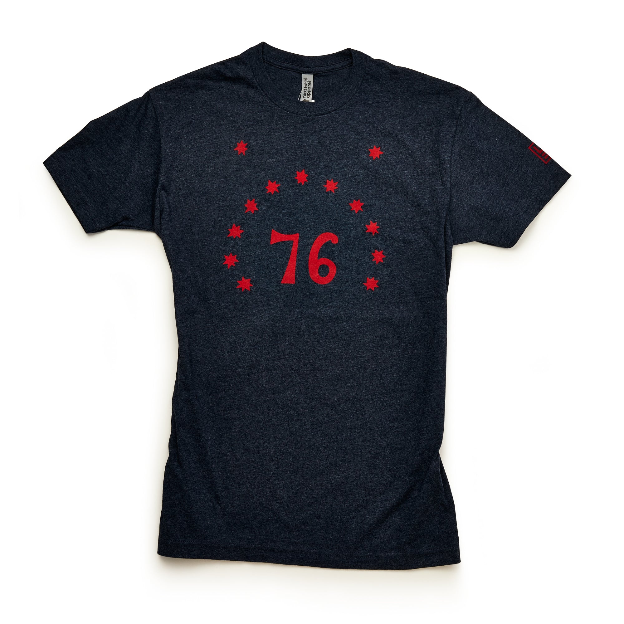 The Bennington 76 T-Shirt in dark gray features the number 76 in red, surrounded by thirteen red stars—a tribute to Revolutionary history—shown laid flat on a white background.