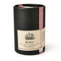 A black cylindrical tin labeled "Bohea Loose Leaf Tea," 3.5 oz, with a ship illustration referencing the Boston Tea Party, finished with a red and white striped ribbon.