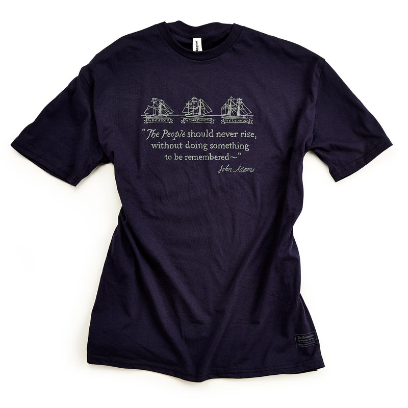 Dark blue Boston Tea Party Ships T-Shirt featuring a graphic of the ships Beaver, Dartmouth, and Eleanor, above a quote by John Adams commemorating the 250th anniversary of American independence.