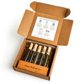 The Boston Tea Party Tea Sampler features five glass tea tubes in a wooden holder labeled Oliver Pluff & Co, presented in an open box with a white card about premium teas of the Boston Tea Party attached to the lid.