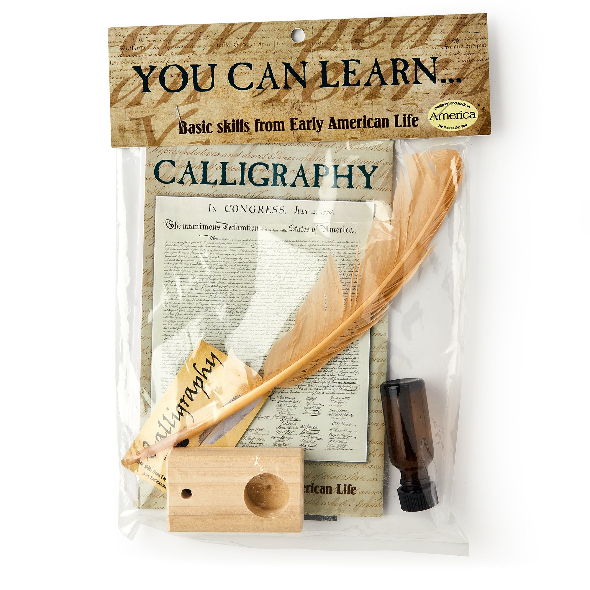 The Calligraphy Kit comes in clear packaging with a large feather quill, wooden ink holder, small ink bottle, and instructional sheets labeled CALLIGRAPHY and YOU CAN LEARN... Basic hand-lettering skills from Early American Life.