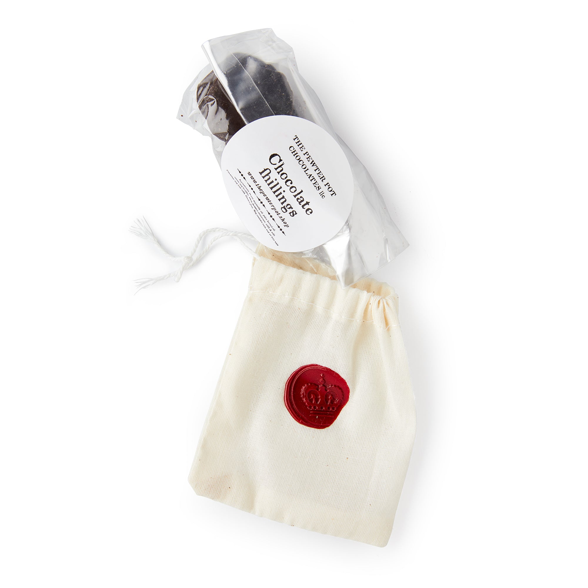 A clear bag of “Chocolate Shillings” coin chocolates sits next to a cream drawstring pouch with a red wax crown seal, evoking the look of colonial currency.