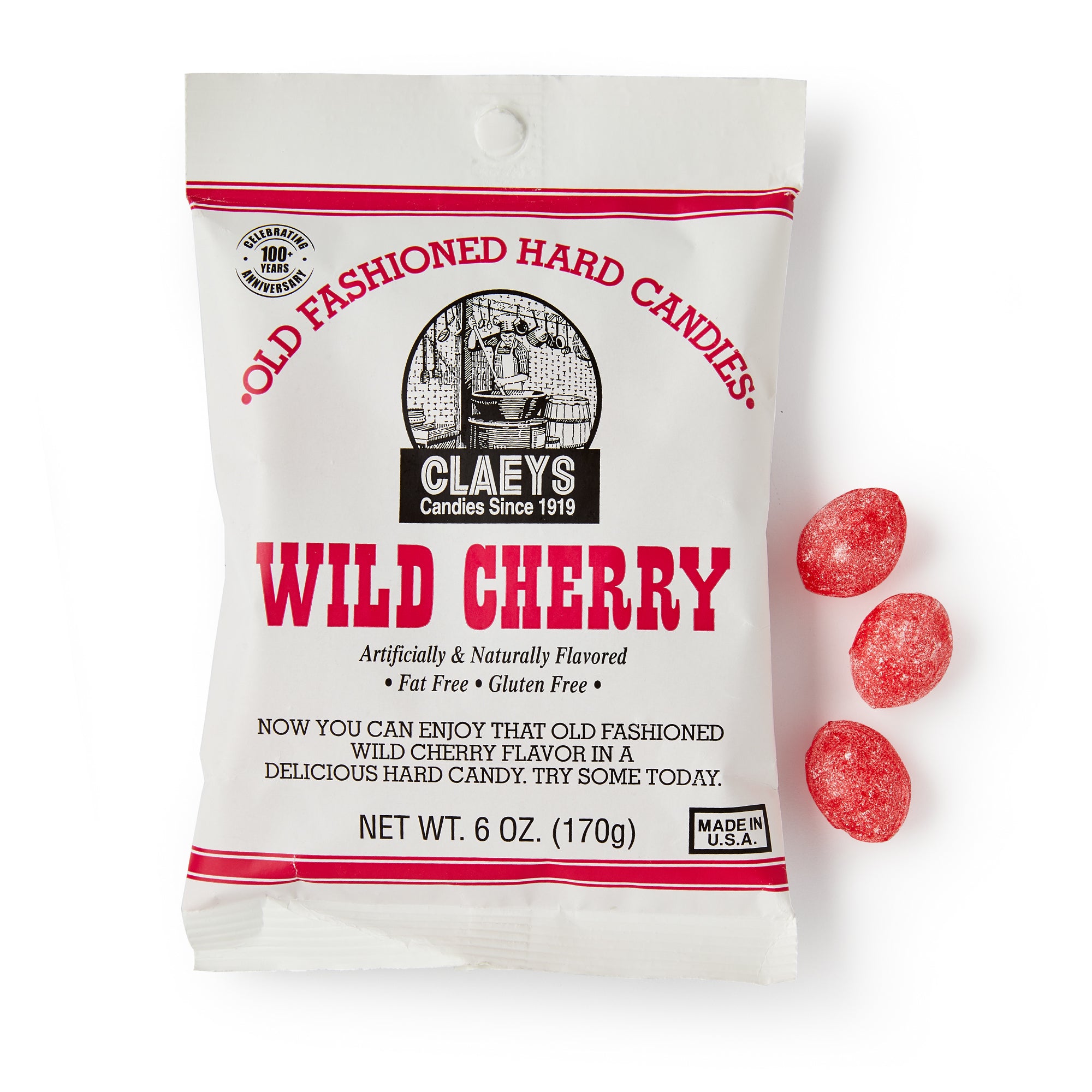 A white bag labeled Wild Cherry Old Fashioned Hard Candies sits beside three red oval cherry candies. The 6 oz packaging notes gluten-free, fat-free qualities and a blend of artificial and natural flavors.