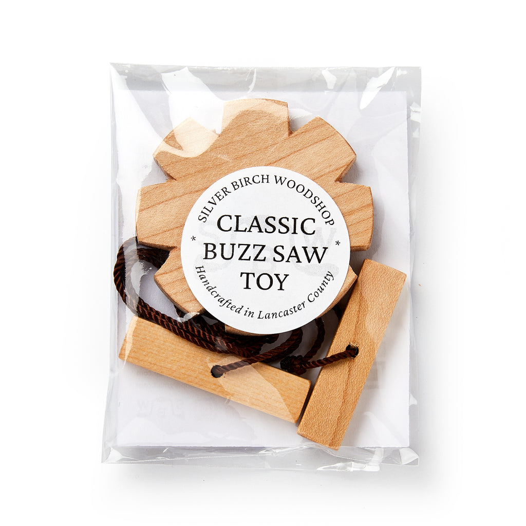 Wooden buzz saw toy in clear packaging with a label on a white background