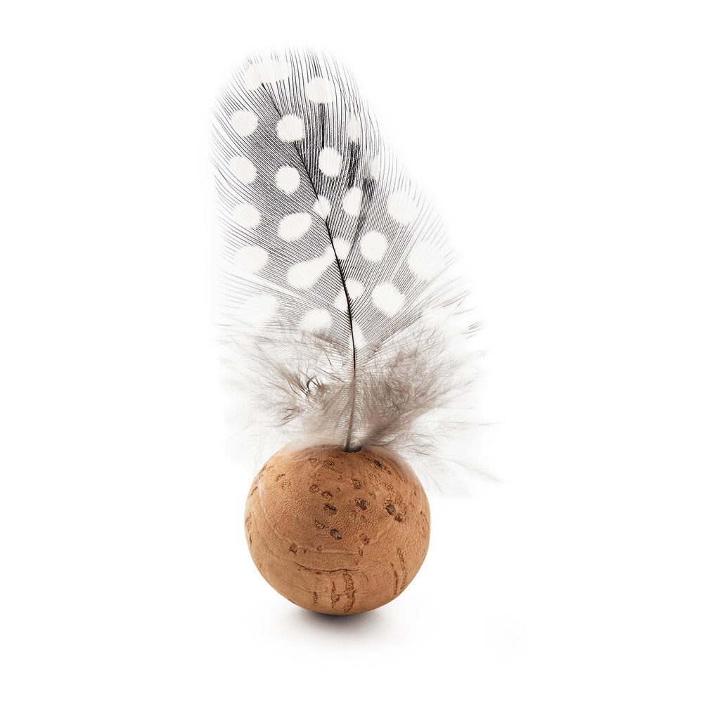 A "Battledore and Shuttlecock" features a light gray feather with white spots set in a round cork stopper, standing upright against a white background.