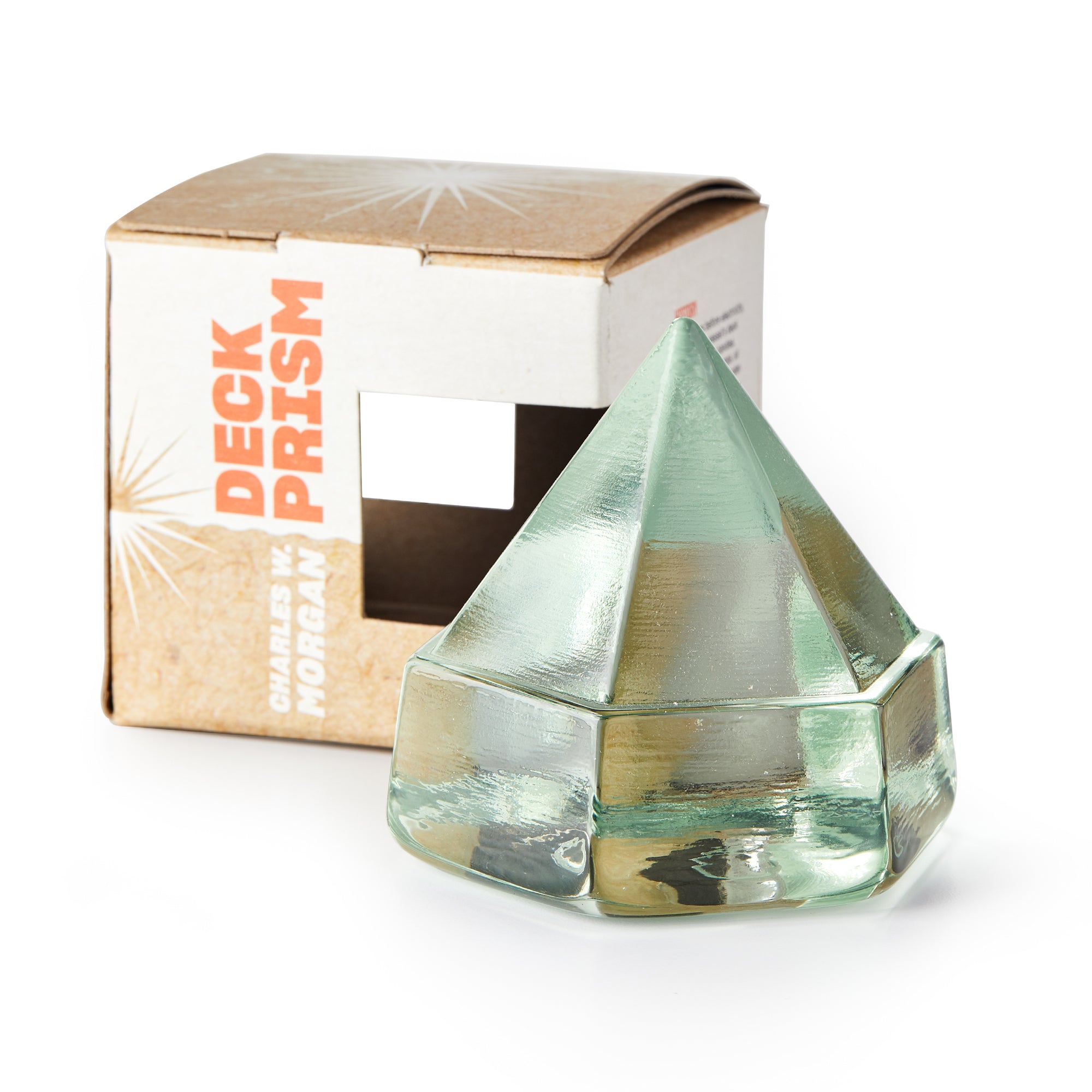 A small green glass pyramid deck prism sits in front of a brown box labeled "Green Deck Prism." Its maritime-inspired design recalls those used on historic ships like the Charles W. Morgan.